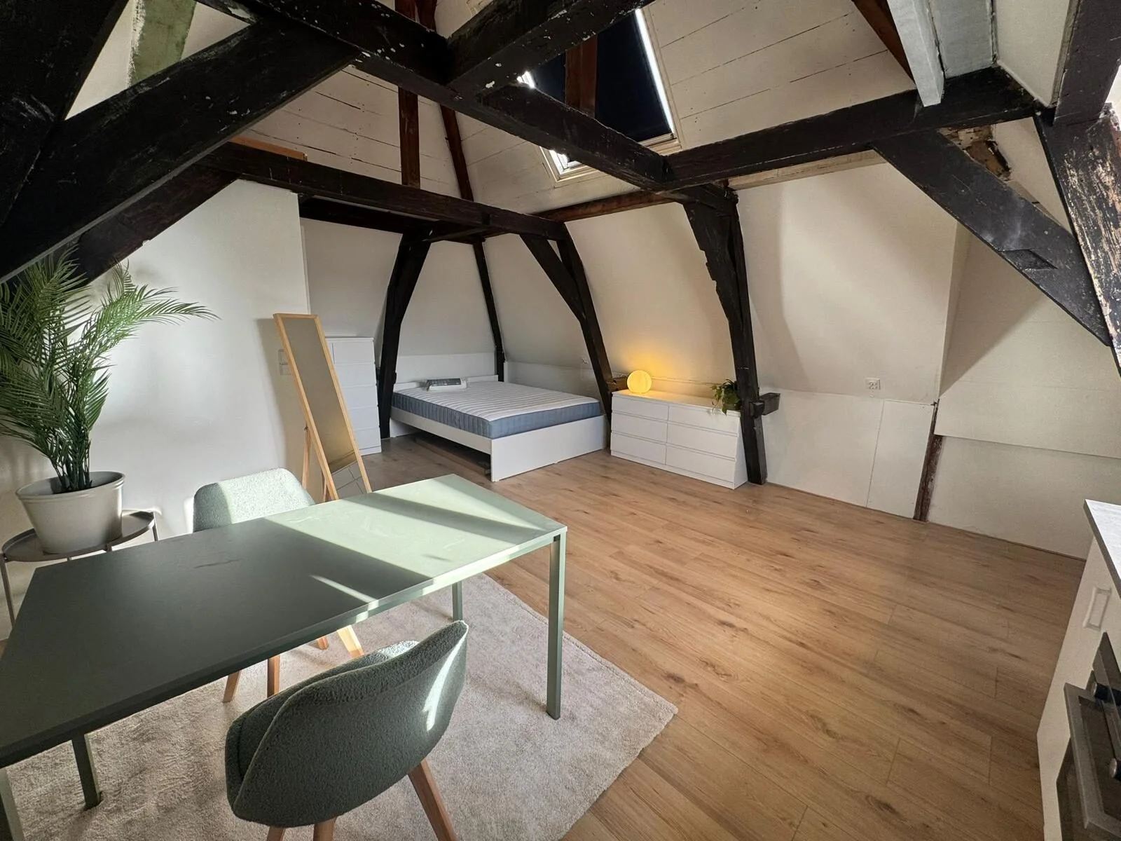 Loft studio at Westeinde with exposed beams, bed and dining table