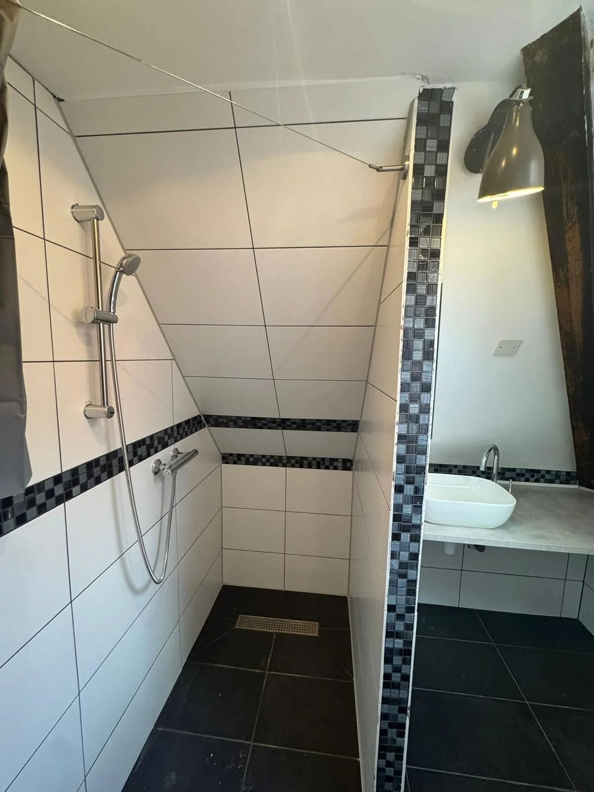 Walk-in shower with white tiles and mosaic border